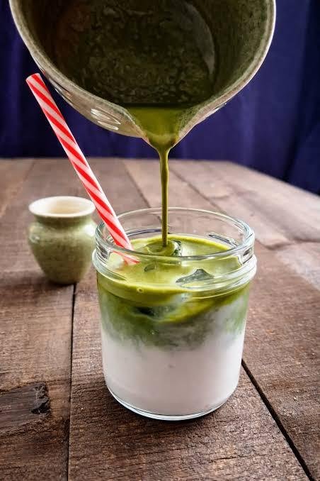 Pouring the matcha over cold milk